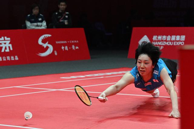 Japan’s Akane Yamaguchi hits a return to Indonesia’s Putri Kusuma Wardani during their women's singles match at the BWF Badminton World Tour Finals at the Hangzhou Olympic Sports Centre Gymnasium in Hangzhou, in eastern China's Zhejiang province on December 18, 2025. (Photo by Jade Gao / AFP)