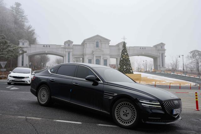 Vehicles leave the entrance to the Cheon Jeong Gung, the Unification Church leader Han Hak-ja's residence in Gapyeong on December 18, 2025. (Photo by Shin Yong-ju / AFP)