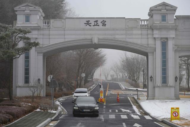 Vehicles leave the entrance to the Cheon Jeong Gung, the Unification Church leader Han Hak-ja's residence in Gapyeong on December 18, 2025. (Photo by Shin Yong-ju / AFP)
