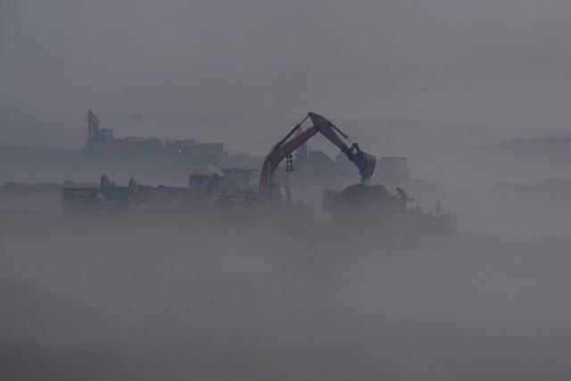 TOPSHOT - A man works at a field engulfed in smog in Lahore on December 18, 2025. (Photo by Arif ALI / AFP)
