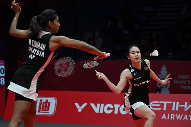 Malaysia’s Pearly Tan (R) and Thinaah Muralitharan play a point during their women's doubles match against Japan’s Rin Iwanaga and Kie Nakanishi at the BWF Badminton World Tour Finals at the Hangzhou Olympic Sports Centre Gymnasium in Hangzhou, in eastern China's Zhejiang province on December 18, 2025. (Photo by Jade Gao / AFP)