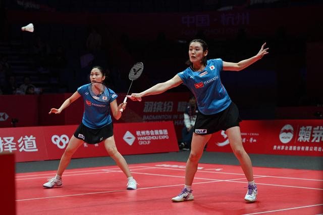 Japan’s Rin Iwanaga (R) and Kie Nakanishi play a point during their women's doubles match against Malaysia’s Pearly Tan and Thinaah Muralitharan at the BWF Badminton World Tour Finals at the Hangzhou Olympic Sports Centre Gymnasium in Hangzhou, in eastern China's Zhejiang province on December 18, 2025. (Photo by Jade Gao / AFP)