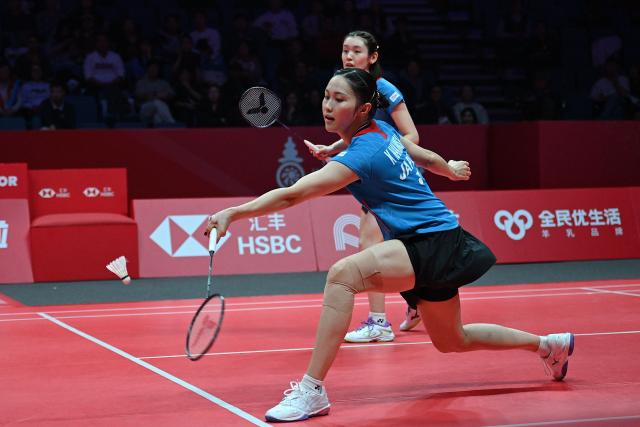 Japan’s Rin Iwanaga and Kie Nakanishi (front) play a point during their women's doubles match against Malaysia’s Pearly Tan and Thinaah Muralitharan at the BWF Badminton World Tour Finals at the Hangzhou Olympic Sports Centre Gymnasium in Hangzhou, in eastern China's Zhejiang province on December 18, 2025. (Photo by Jade Gao / AFP)