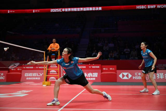 Japan’s Rin Iwanaga (L) and Kie Nakanishi play a point during their women's doubles match against Malaysia’s Pearly Tan and Thinaah Muralitharan at the BWF Badminton World Tour Finals at the Hangzhou Olympic Sports Centre Gymnasium in Hangzhou, in eastern China's Zhejiang province on December 18, 2025. (Photo by Jade Gao / AFP)