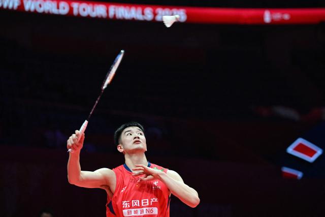 China’s Li Shifeng hits a return to Japan’s Kodai Naraoka during their men's singles match at the BWF Badminton World Tour Finals at the Hangzhou Olympic Sports Centre Gymnasium in Hangzhou, in eastern China's Zhejiang province on December 18, 2025. (Photo by Jade Gao / AFP)
