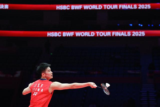 China’s Li Shifeng hits a return to Japan’s Kodai Naraoka during their men's singles match at the BWF Badminton World Tour Finals at the Hangzhou Olympic Sports Centre Gymnasium in Hangzhou, in eastern China's Zhejiang province on December 18, 2025. (Photo by Jade Gao / AFP)