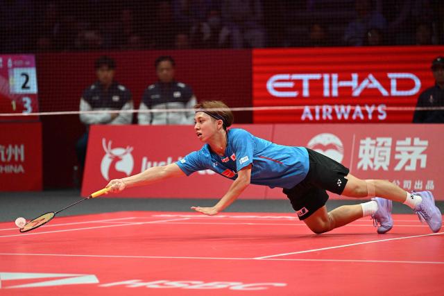 Japan’s Kodai Naraoka hits a return to China’s Li Shifeng during their men's singles match at the BWF Badminton World Tour Finals at the Hangzhou Olympic Sports Centre Gymnasium in Hangzhou, in eastern China's Zhejiang province on December 18, 2025. (Photo by Jade Gao / AFP)