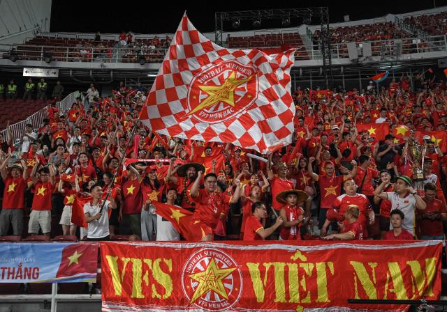 Supporters of Vietnam cheer for their team prior to the men's football final match between Thailand and Vietnam during the 33rd Southeast Asian Games (SEA Games) at Rajamangala National Stadium in Bangkok on December 18, 2025. (Photo by Lillian SUWANRUMPHA / AFP)