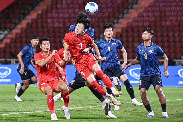 Vietnam's forward Dinh Bac Nguyen (C) fights for the ball during the men's football final match between Thailand and Vietnam during the 33rd Southeast Asian Games (SEA Games) at Rajamangala National Stadium in Bangkok on December 18, 2025. (Photo by Lillian SUWANRUMPHA / AFP)