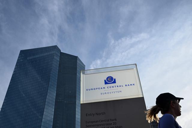 A woman runs past the European Central Bank (ECB) headquarters in Frankfurt am Main, western Germany, on December 18, 2025, prior to the meeting on the Eurozone's monetary policy,. (Photo by Kirill KUDRYAVTSEV / AFP)