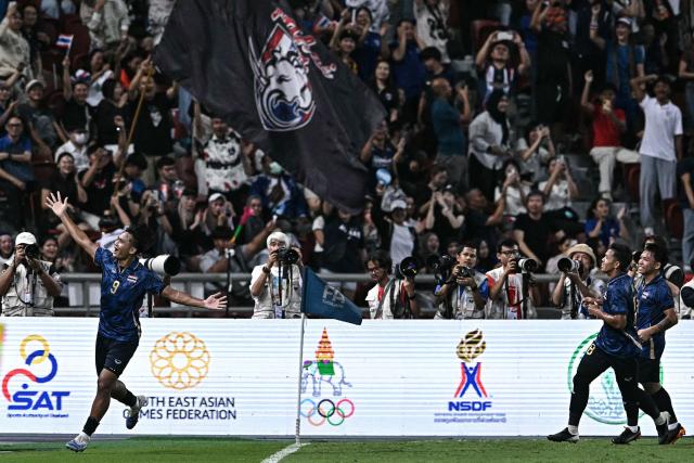 Thailand's forward Yotsakorn Burapha (L) celebrates with teammates after scoring a goal during the men's football final match between Thailand and Vietnam during the 33rd Southeast Asian Games (SEA Games) at Rajamangala National Stadium in Bangkok on December 18, 2025. (Photo by Lillian SUWANRUMPHA / AFP)