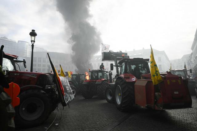 A farmer stands on a tractor near the European Parliament at the Place du Luxembourg, during a farmers' protest to denounce the reforms of the Common Agricultural Policy (CAP) and trade agreements such as the Mercosur, in Brussels, on December 18, 2025, organised by Copa-Cogeca, the main association representing farmers and agricultural cooperatives in the EU. EU Farmers, particularly in France, worry the Mercosur deal -- which will be discussed at the EU leaders meeting -- will see them undercut by a flow of cheaper goods from agricultural giant Brazil and its neighbours. They also oppose plans put forward by the European Commission to overhaul the 27-nation bloc's huge farming subsidies, fearing less money will flow their way. (Photo by NICOLAS TUCAT / AFP)