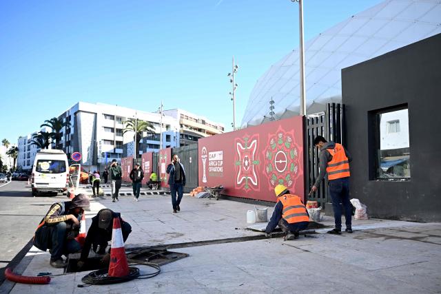 Workers make the final touches to the outside of the Al-Medina Stadium in Rabat, on December 18, 2025, ahead of the Africa Cup of Nations (AFCON). The competition begins on December 21. (Photo by Paul ELLIS / AFP)