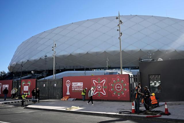 Workers make the final touches to the outside of the Al-Medina Stadium in Rabat, on December 18, 2025, ahead of the Africa Cup of Nations (AFCON). The competition begins on December 21. (Photo by Paul ELLIS / AFP)