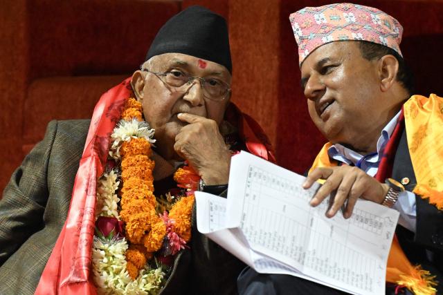 Former Nepali Prime Minister and newly elected leader of the Communist Party of Nepal - Unified Marxist Leninist (CPN-UML), KP Sharma Oli (L) looks on during the party's 11th general convention in Kathmandu on December 18, 2025. Members of ousted Nepali prime minister KP Sharma Oli's political party voted for him to retain leadership of the organisation on December 18, meaning he will oversee its preparations for national elections next year. (Photo by PRAKASH MATHEMA / AFP)