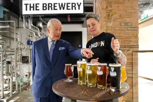 Britain's King Charles III is shown the Guinness range, including limited-edition seasonal brews, by Master Brewer Hollie Stephenson (R) during his visit to officially open the Guinness Open Gate Brewery London on December 18, 2025. The Guinness Open Gate Brewery, a Ј73 million investment, contains a microbrewery, visitor experience, restaurants, shops, and events space, and will serve as the UK southern hub for Diageo’s award-winning Learning for Life programme. (Photo by Chris Jackson / POOL / AFP)
