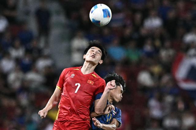Vietnam's forward Dinh Bac Nguyen (L) and Thailand's midfielder Siraphop Wandee (R) fight for the ball in the men's football final match between Thailand and Vietnam during the 33rd Southeast Asian Games (SEA Games) at Rajamangala National Stadium in Bangkok on December 18, 2025. (Photo by Lillian SUWANRUMPHA / AFP)