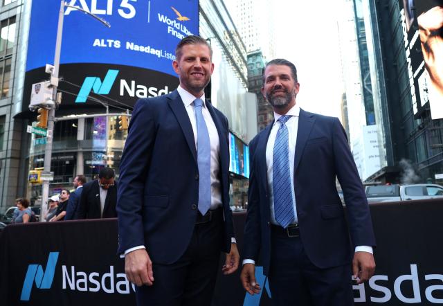 (FILES) Eric Trump (L), newly appointed ALT5 Board Director, and ALT5 Board Observer Donald Trump Jr. pose outside Nasdaq in Times Square in New York on August 13, 2025 as World Liberty Financial and ALT5 Sigma ring the Nasdaq Stock Market opening Bell. Trump Media & Technology Group, the struggling company that owns the US president's Truth Social platform, announced on December 18, 2025 a $6 billion merger with fusion power company TAE Technologies, in an unexpected pivot into energy technology. (Photo by TIMOTHY A. CLARY / AFP)