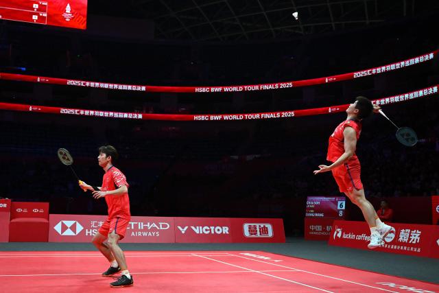 China’s Liang Weikeng and Wang Chang play a point during their men’s doubles match against Malaysia’s Aaron Chia and Soh Wooi Yik at the BWF Badminton World Tour Finals at the Hangzhou Olympic Sports Centre Gymnasium in Hangzhou, in eastern China's Zhejiang province on December 18, 2025. (Photo by Jade Gao / AFP)