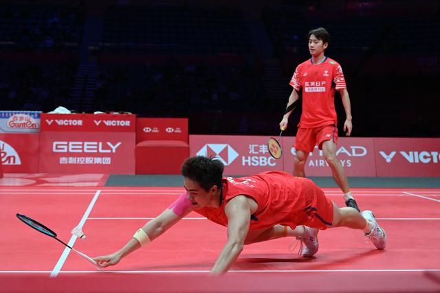 China’s Liang Weikeng and Wang Chang play a point during their men’s doubles match against Malaysia’s Aaron Chia and Soh Wooi Yik at the BWF Badminton World Tour Finals at the Hangzhou Olympic Sports Centre Gymnasium in Hangzhou, in eastern China's Zhejiang province on December 18, 2025. (Photo by Jade Gao / AFP)