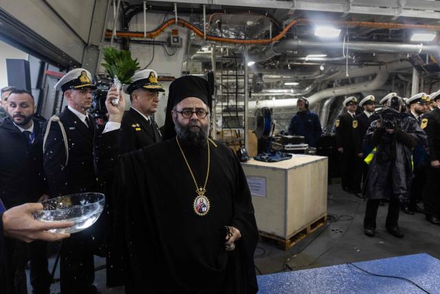 Archbishop of France Dimitrios Ploumis blesses the frigate during the delivery ceremony of the Defence and Intervention frigate HS Kimon to the Greek Navy in Lorient, western France on December 18, 2025. (Photo by Fred TANNEAU / AFP)