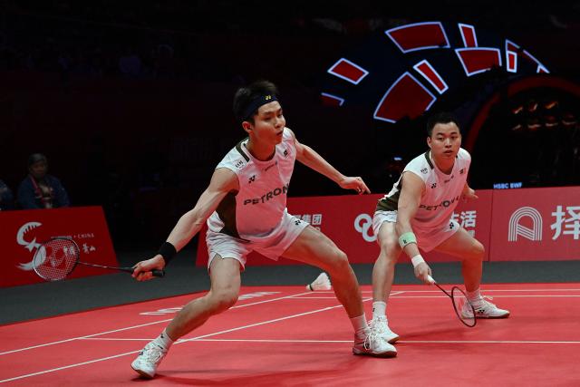 Malaysia’s Aaron Chia and Soh Wooi Yik play a point during their men’s doubles match against China’s Liang Weikeng and Wang Chang at the BWF Badminton World Tour Finals at the Hangzhou Olympic Sports Centre Gymnasium in Hangzhou, in eastern China's Zhejiang province on December 18, 2025. (Photo by Jade Gao / AFP)