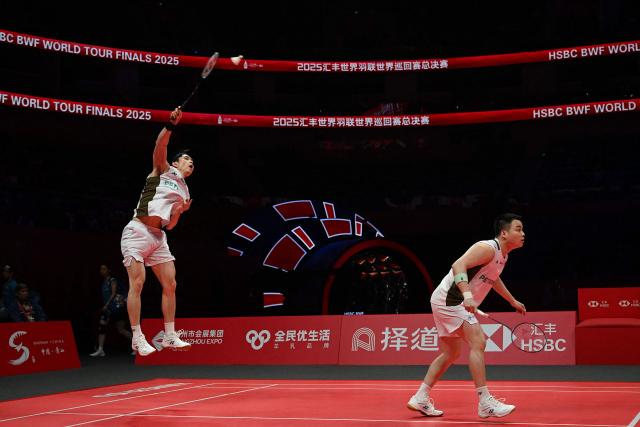 Malaysia’s Aaron Chia and Soh Wooi Yik play a point during their men’s doubles match against China’s Liang Weikeng and Wang Chang at the BWF Badminton World Tour Finals at the Hangzhou Olympic Sports Centre Gymnasium in Hangzhou, in eastern China's Zhejiang province on December 18, 2025. (Photo by Jade Gao / AFP)