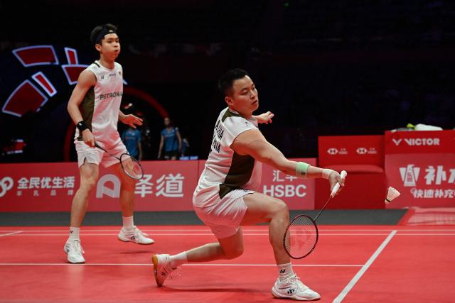 Malaysia’s Aaron Chia and Soh Wooi Yik play a point during their men’s doubles match against China’s Liang Weikeng and Wang Chang at the BWF Badminton World Tour Finals at the Hangzhou Olympic Sports Centre Gymnasium in Hangzhou, in eastern China's Zhejiang province on December 18, 2025. (Photo by Jade Gao / AFP)