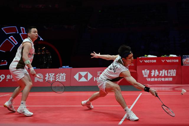 Malaysia’s Aaron Chia and Soh Wooi Yik play a point during their men’s doubles match against China’s Liang Weikeng and Wang Chang at the BWF Badminton World Tour Finals at the Hangzhou Olympic Sports Centre Gymnasium in Hangzhou, in eastern China's Zhejiang province on December 18, 2025. (Photo by Jade Gao / AFP)