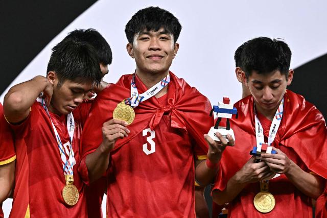 Vietnam's defender Ly Duc Pham (C) poses with his gold medal after winning the men's football final match against Thailand during the 33rd Southeast Asian Games (SEA Games) at Rajamangala National Stadium in Bangkok on December 18, 2025. (Photo by Lillian SUWANRUMPHA / AFP)