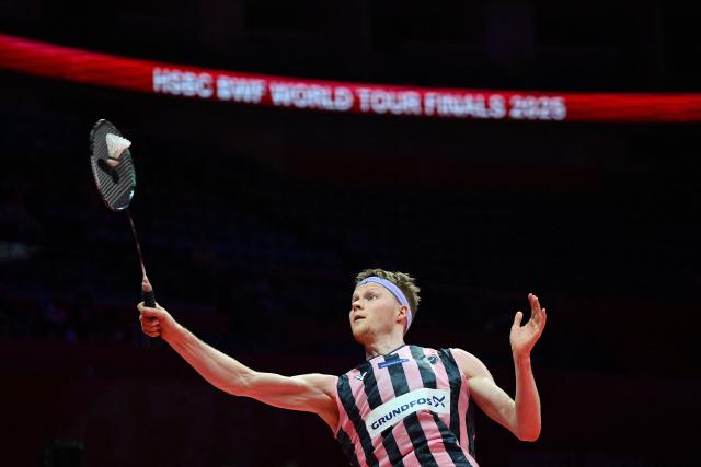 Denmark’s Anders Antonsen hits a return to Indonesia’s Jonatan Christie during their men's singles match at the BWF Badminton World Tour Finals at the Hangzhou Olympic Sports Centre Gymnasium in Hangzhou, in eastern China's Zhejiang province on December 18, 2025. (Photo by Jade Gao / AFP)