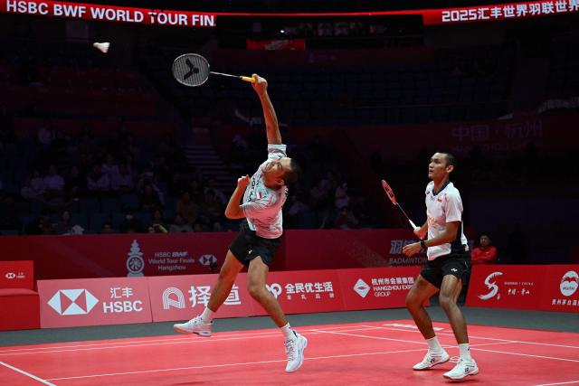 Indonesia’s Fajar Alfian and Muhammad Shohibul Fikri play a point during their men's doubles match against India’s Satwiksairaj Rankireddy and Chirag Shetty at the BWF Badminton World Tour Finals at the Hangzhou Olympic Sports Centre Gymnasium in Hangzhou, in eastern China's Zhejiang province on December 18, 2025. (Photo by Jade Gao / AFP)