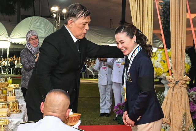 This pool photo taken and released on December 18, 2025 shows Thailand's King Maha Vajiralongkorn presenting the gold medal to Queen Suthida after her victory in the mixed keelboat SSL47 sailing event during the 33rd Southeast Asian Games (SEA Games) at the Ocean marina yacht club in Chonburi province. (Photo by POOL / AFP)