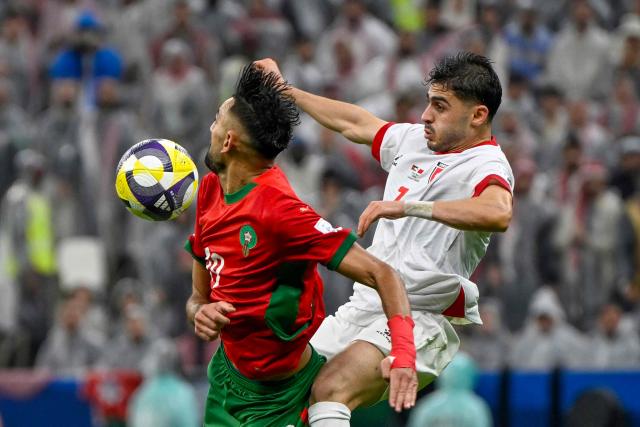 Morocco's defender #19 Hamza Al Moussaoui is marked by Jordan's forward #7 Mohammad Abu Zraiq during the FIFA Arab Cup 2025 final football match between Jordan and Morocco at the Lusail Stadium  Stadium, in Lusail on December 18, 2025. (Photo by Mahmud HAMS / AFP)