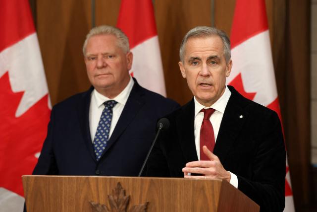 Canadian Prime Minister Mark Carney (R) speaks as Premier of Ontario Doug Ford listens during a news conference on Parliament Hill, December 18, 2025 in Ottawa, Canada. (Photo by Dave Chan / AFP)