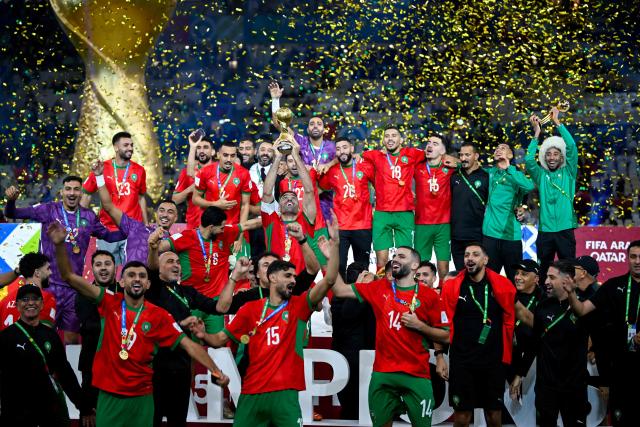 Morroco's players celebrate with the trophy after winning the FIFA Arab Cup 2025 final football match between Jordan and Morocco at the Lusail Stadium  Stadium, in Lusail on December 18, 2025. (Photo by Mahmud HAMS / AFP)
