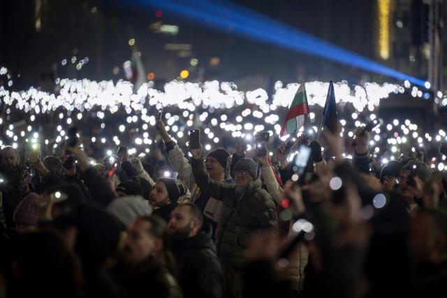 Protesters shine their phones' flashlights as thousands gather to take part in an anti-government demonstration in Sofia on December 18, 2025. (Photo by Nikolay DOYCHINOV / AFP)