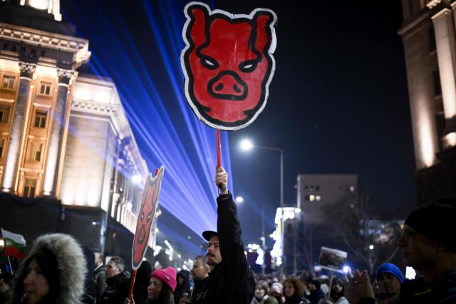 A protester holds a placard as thousands gather to take part in an anti-government demonstration in Sofia on December 18, 2025. (Photo by Nikolay DOYCHINOV / AFP)