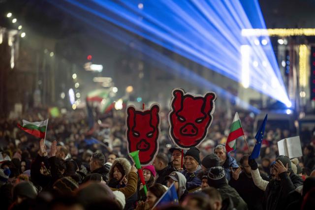 Protesters hold placards as thousands gather to take part in an anti-government demonstration in Sofia on December 18, 2025. (Photo by Nikolay DOYCHINOV / AFP)