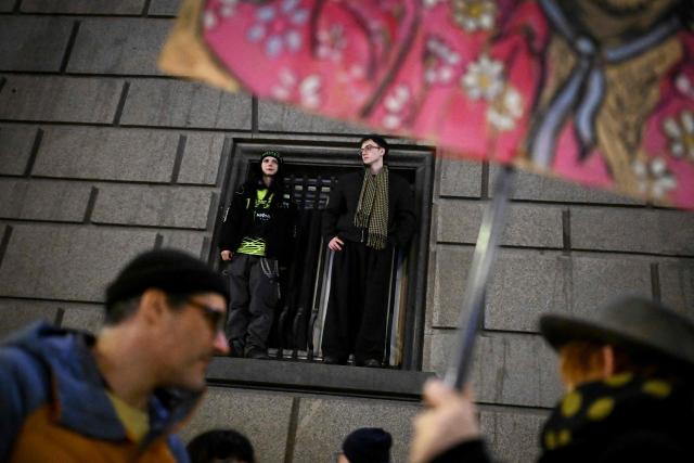 Protester stand on the ledge of the Bulgarian Parliament building during an anti-government demonstration in Sofia on December 18, 2025. (Photo by Nikolay DOYCHINOV / AFP)