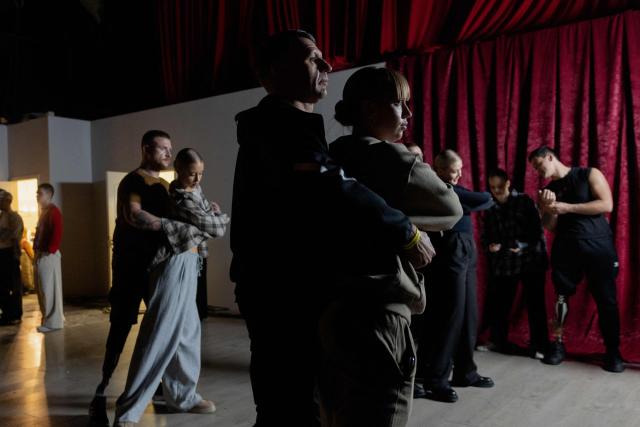 TOPSHOT - Ukrainian veterans dance during a rehearsal ahead of filming for the Christmas charity television show "Dancing with the Stars: Movement for Life" during a blackout in Kyiv on December 18, 2025, amid the Russian invasion of Ukraine. Seven Ukrainian veterans from Superhumans (rehabilitation clinic) are participating in a Christmas charity TV show "Dancing with the Stars: Movement for Life", which aims to raise funds for the targeted evacuation of wounded defenders, saving their lives and giving them a chance for a full recovery. (Photo by Tetiana DZHAFAROVA / AFP)