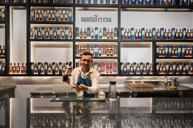 A bartender prepares a drink at the Santa Teresa rum factory in La Victoria, Aragua state, Venezuela, on December 17, 2025. (Photo by Federico PARRA / AFP)