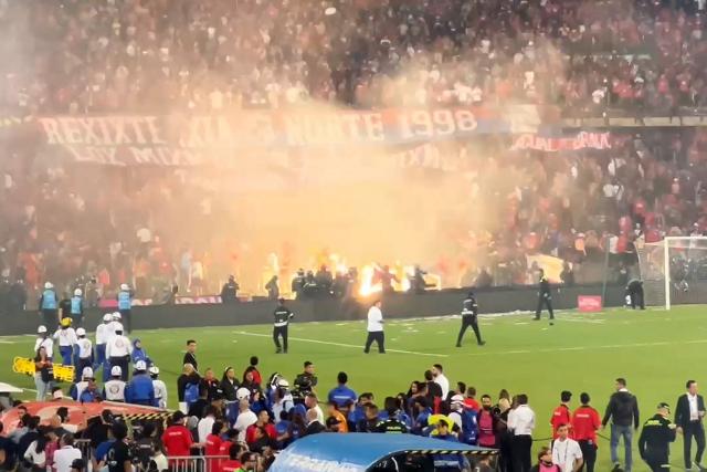 This AFPTV video grab shows clashes between fans during the Colombia's cup final football match between Deportivo Independiente Medellin and Atletico Nacional at the Atanasio Girardot stadium in Medellin, Colombia on December 17, 2025. At least 59 people were injured in clashes between football fans during Colombia's cup final in Medellin on the night of December 17, 2025, local authorities said. The unrest broke out at the end of the match which saw Atletico Nacional beat fellow Medellin side, Deportivo Independiente Medellin, 1-0. (Photo by AFPTV teams / AFPTV / AFP)