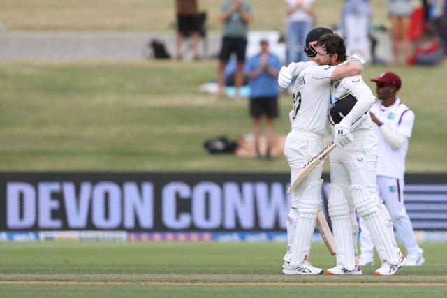 New Zealand’s Devon Conway celebrates his double century with Kane Williamson (L) during day two of the 3rd international Test cricket match between New Zealand and West Indies at Bay Oval in Mount Maunganui on December 19, 2025. (Photo by Michael Bradley / AFP)