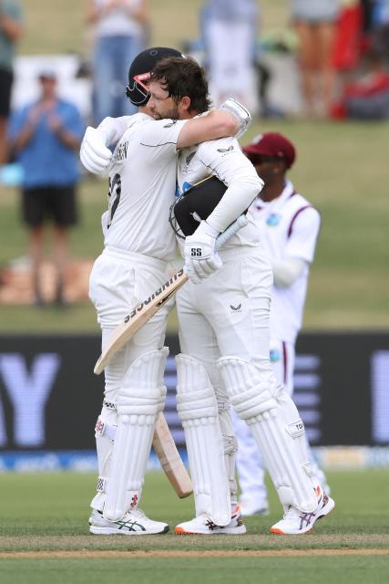 New Zealand’s Devon Conway celebrates his double century with Kane Williamson (L) during day two of the 3rd international Test cricket match between New Zealand and West Indies at Bay Oval in Mount Maunganui on December 19, 2025. (Photo by Michael Bradley / AFP)