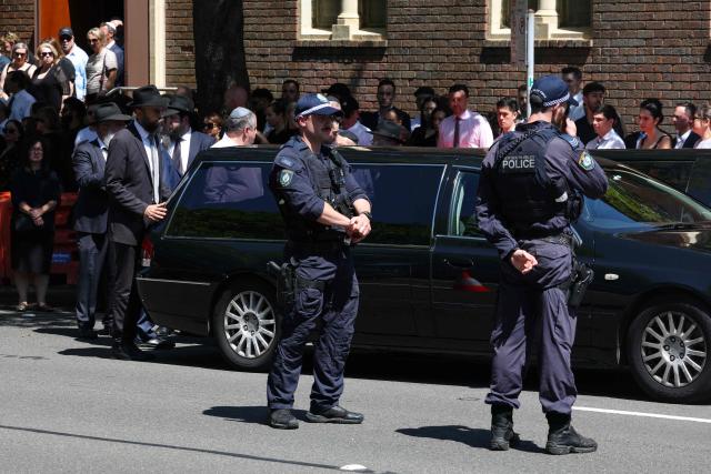 Police stand guard beside a hearse after the funeral of Boris and Sofia Gurman, who were killed in the December 14 Bondi Beach shooting attack, at the Sydney Chevra Kadisha in Sydney on December 19, 2025. Father-and-son gunmen are accused of firing into crowds at a beachside Jewish festival on December 14, killing 15 in an attack authorities linked to "Islamic State ideology". (Photo by DAVID GRAY / AFP)