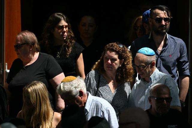 Mourners leave after the funeral of Boris and Sofia Gurman, who were killed in the December 14 Bondi Beach shooting attack, at the Sydney Chevra Kadisha in Sydney on December 19, 2025. Father-and-son gunmen are accused of firing into crowds at a beachside Jewish festival on December 14, killing 15 in an attack authorities linked to "Islamic State ideology". (Photo by Saeed KHAN / AFP)