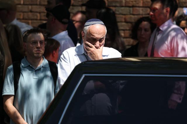 A man reacts as he looks at the hearse after the funeral of Boris and Sofia Gurman, who were killed in the December 14 Bondi Beach shooting attack, at the Sydney Chevra Kadisha in Sydney on December 19, 2025. Father-and-son gunmen are accused of firing into crowds at a beachside Jewish festival on December 14, killing 15 in an attack authorities linked to "Islamic State ideology". (Photo by DAVID GRAY / AFP)