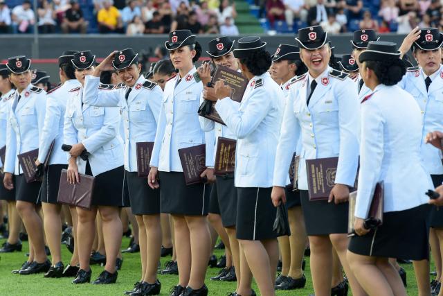 Female police officers attend the graduation ceremony of nearly 5,000 new noncommissioned officers of the National Police at the Ueno Defensores del Chaco stadium in Asuncion on December 18, 2025. The ceremony was led by Paraguay's President Santiago Pena, together with Interior Minister Enrique Riera Escudero and the National Police Commander, Carlos Benitez, and included the symbolic awarding of diplomas, the oath of the new noncommissioned officers, and messages from the main national authorities. (Photo by DANIEL DUARTE / AFP)