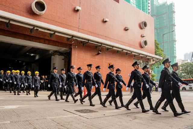 Fire Services Department members are seen at the funeral of the firefighter Ho Wai-ho, who died in the deadly fire at the Wang Fuk Court residential estate in Tai Po district, at the Universal Funeral Parlour in Hung Hom, Hong Kong, on December 19, 2025. (Photo by Leung Man Hei / AFP)